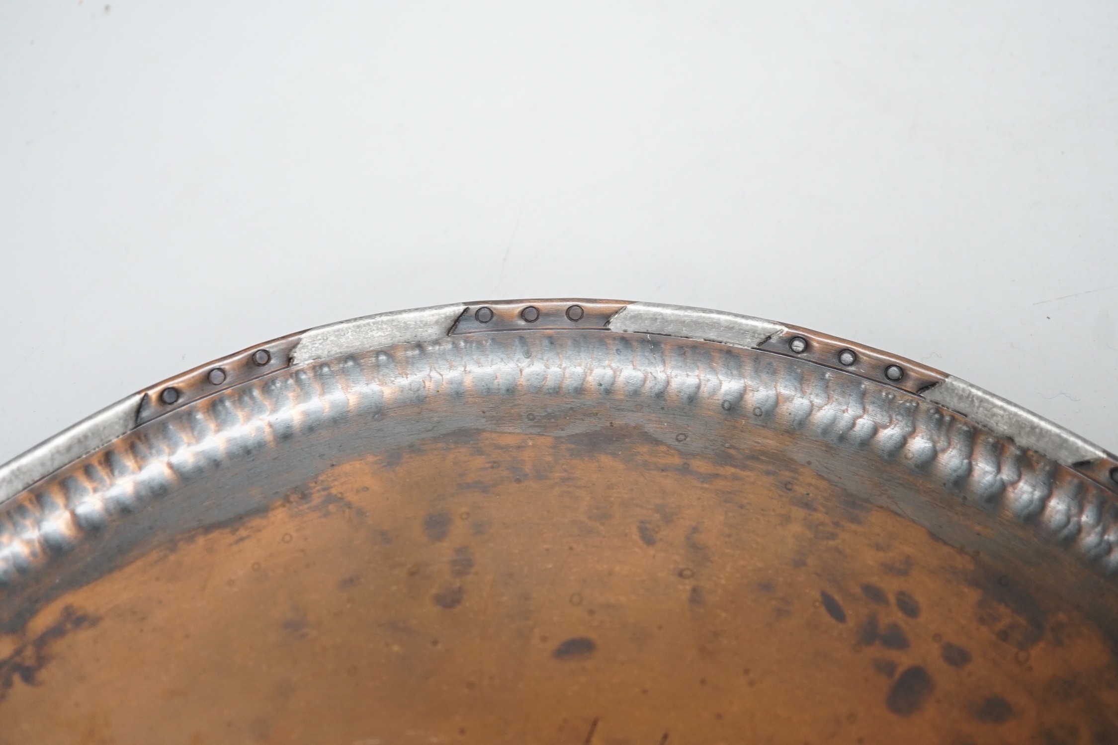 Paul Gillis. An Arts & Crafts copper tray and an Arts & Crafts buckle, tray 28cm diameter